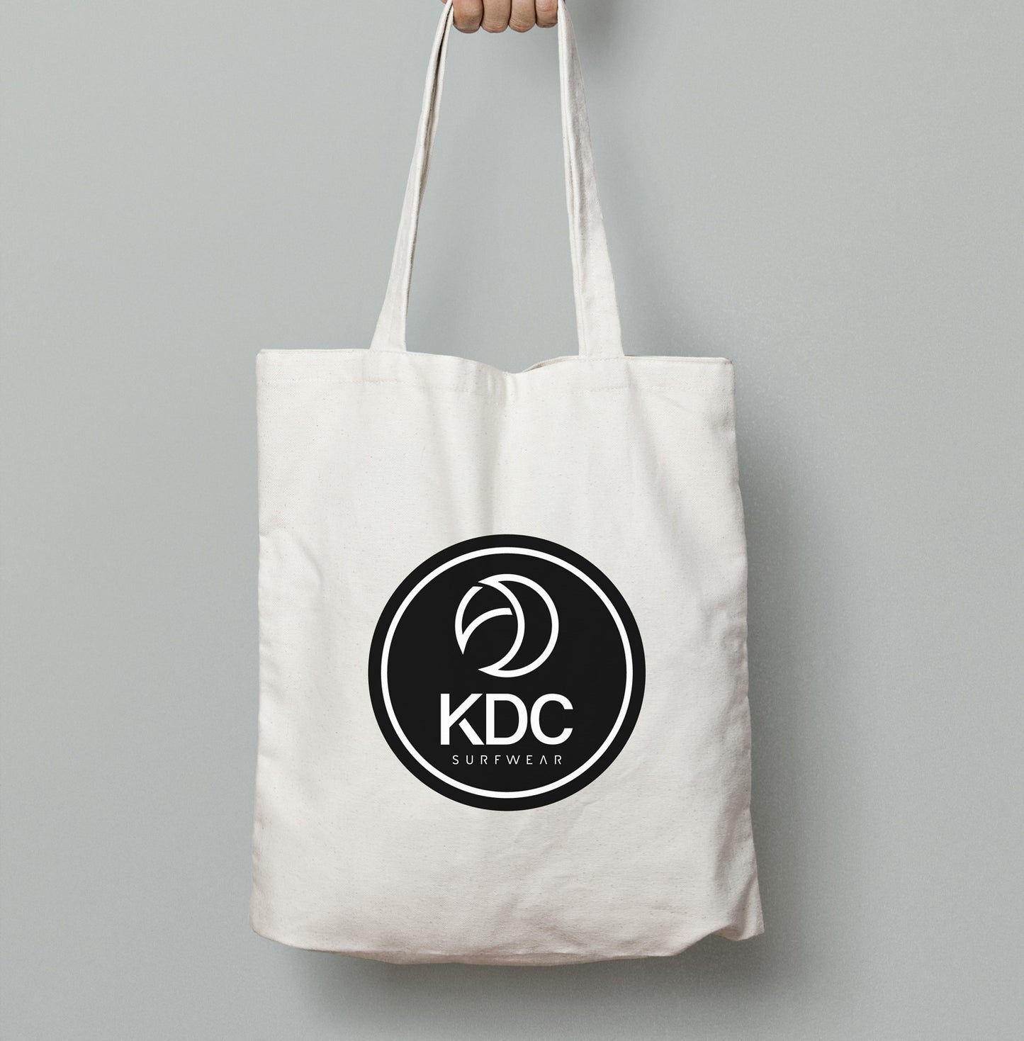 Sac tote bag KDC-Surfwear en toile, noir avec poignées en corde, idéal pour transporter des affaires avec style et praticité.