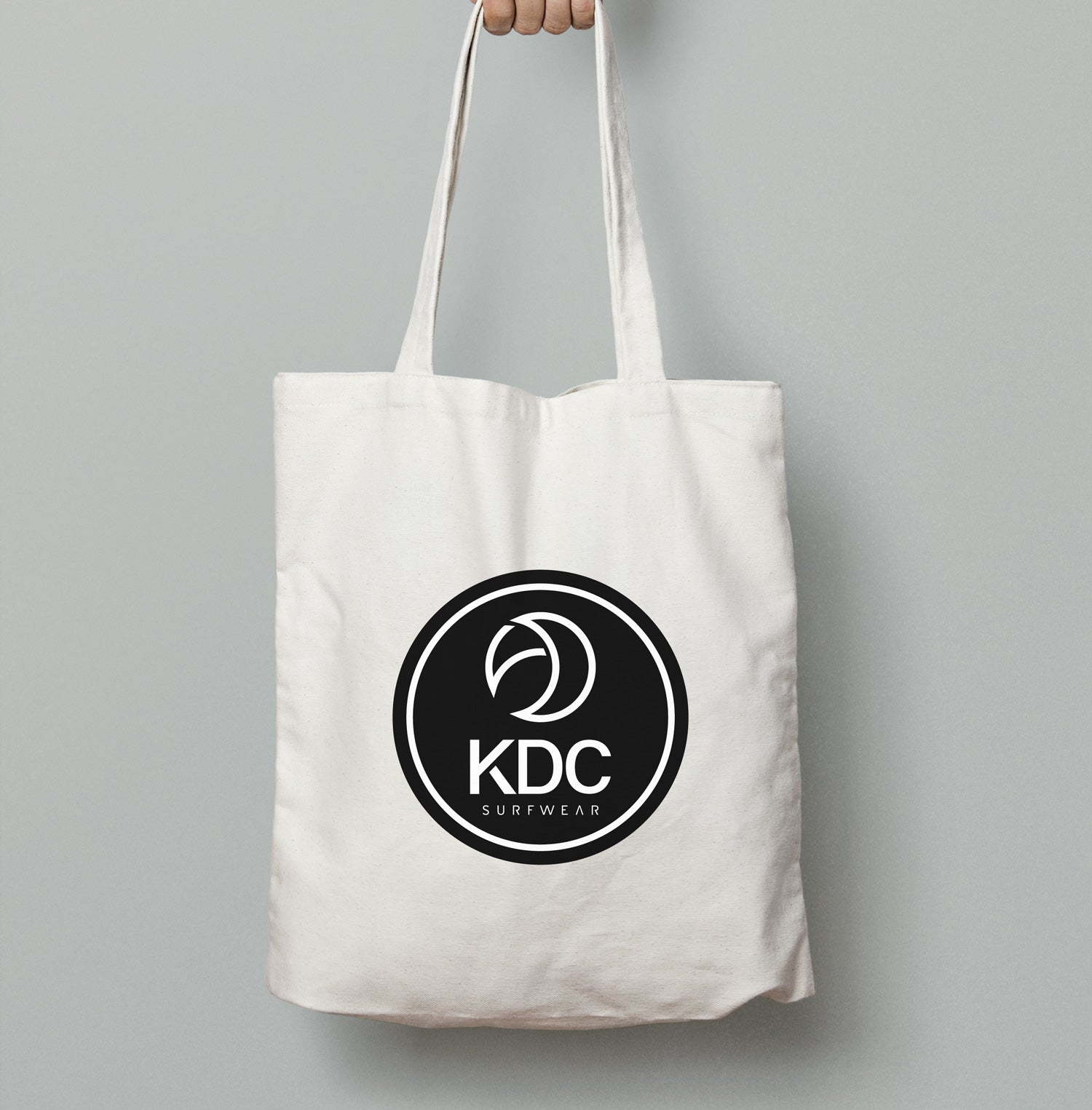 Sac tote bag KDC-Surfwear en toile, noir avec poignées en corde, idéal pour transporter des affaires avec style et praticité.