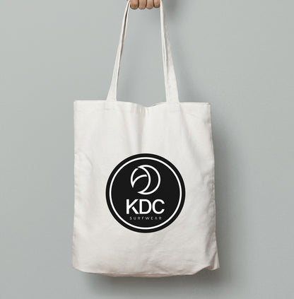 Sac tote bag KDC-Surfwear en toile, noir avec poignées en corde, idéal pour transporter des affaires avec style et praticité.